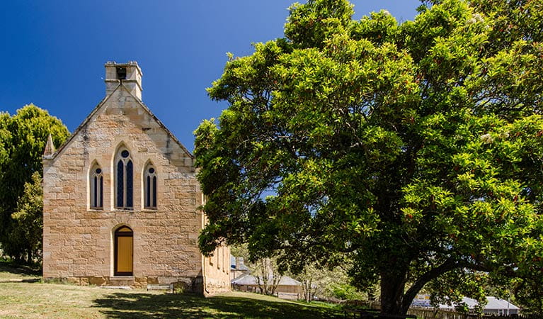 The exterior of St Bernard's Church next to trees in Hartley Historic Site. Photo: John Spencer &copy; DPIE