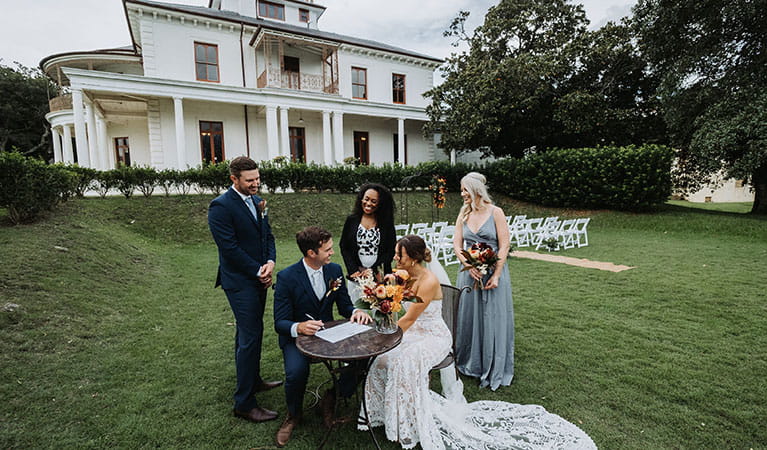 A couple with a bridesmaid, groomsman and celebrant at a signing table on the lawn of Strickland Estate. Photo &copy; Matt Horspool 