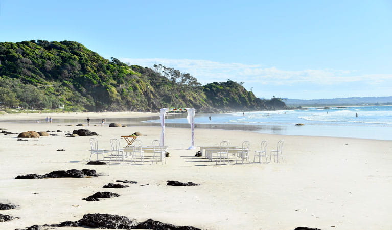A wedding arch, benches and chairs set up for a wedding on Wategos Beach in Cape Byron State Conservation Area. Photo: Fiora Sacco &copy; DPIE
