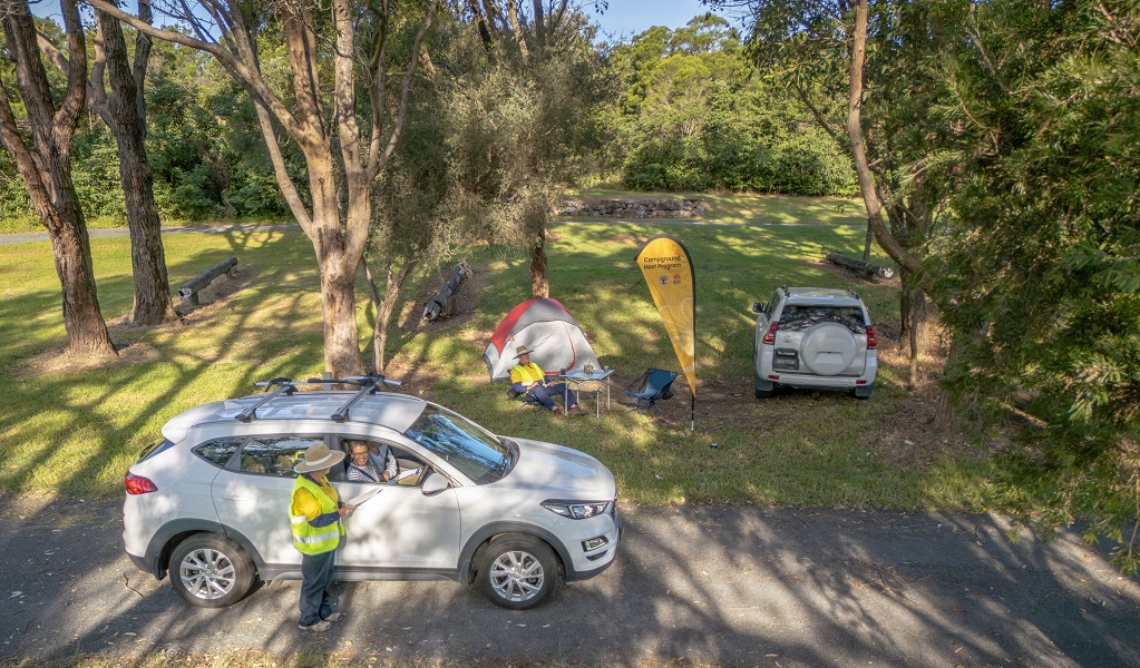 A volunteer campground hosts greets visitors in their car as they arrive at a campground, Killalea Regional Park. Credit: John Spencer/DCCEEW &copy; DCCEEW